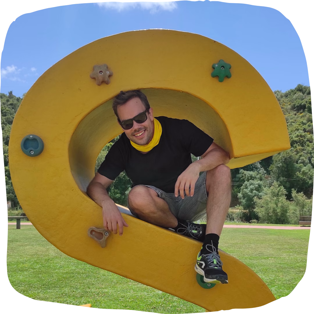 Energetic tour guide posing inside a big yellow sculpture in the Algarve, bringing fun and good vibes.